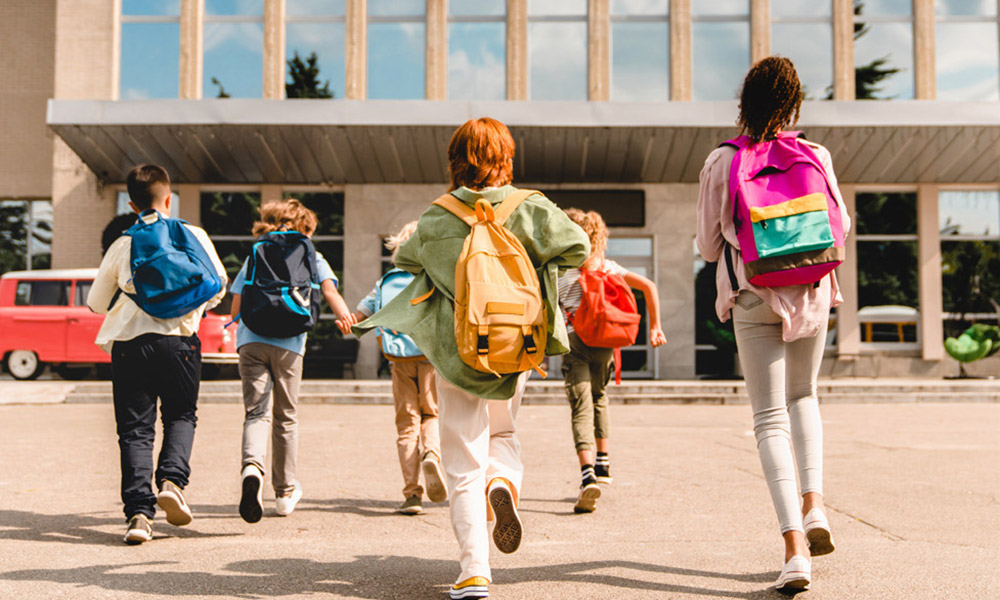 Group of kids running towards school door